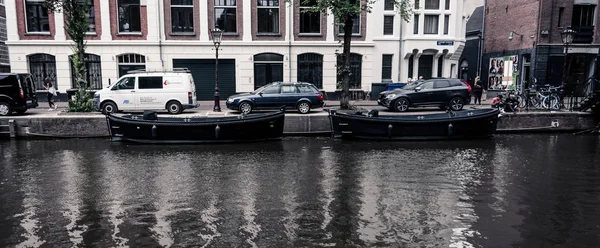 Amsterdam / Niederlande / 18 de julio de 2019: Dos grandes barcos negros flotando en el canal de Ámsterdam — Foto de Stock