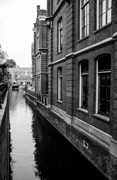 Schöner schmaler Wasserkanal, der das alte Gebäude in Schwarz-Weiß widerspiegelt — Stockfoto