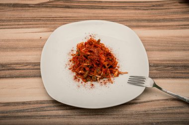 Beyaz tabakta kırmızı soslu mükemmel bir spagetti manzarası.
