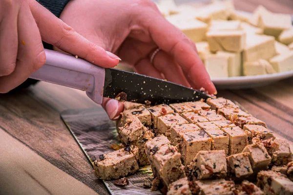 用锋利的黑色刀切在塑料盘上的健康豆腐食品 — 图库照片