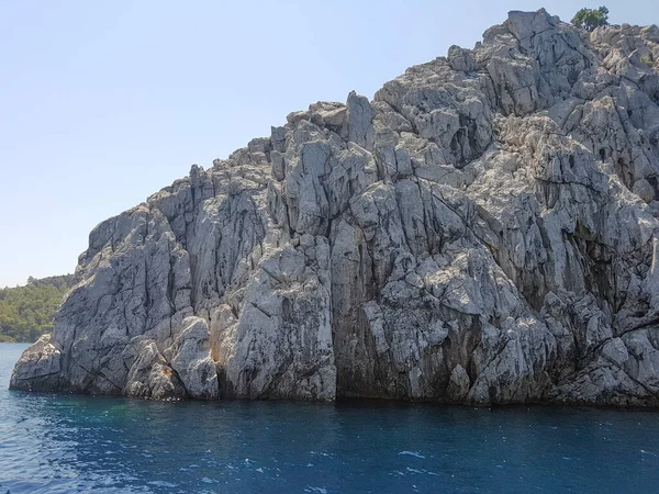 Massive rocks by the sea, blue sky and sea, sea waves