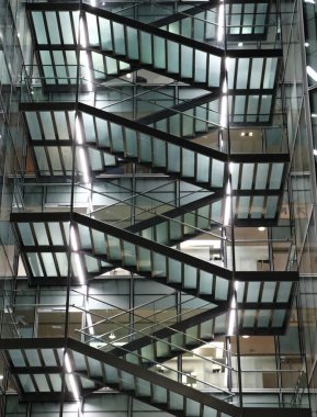 Parlak ışık ve arka planla aydınlatılmış büyük bir binanın merdivenleri.