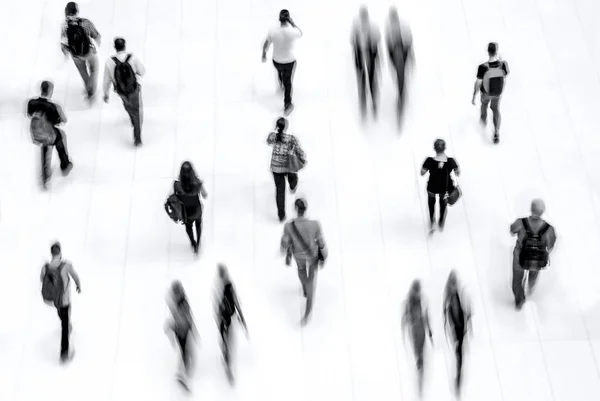 abstract image of people in the lobby of a modern business center with a blurred background and monochrome blue tonality