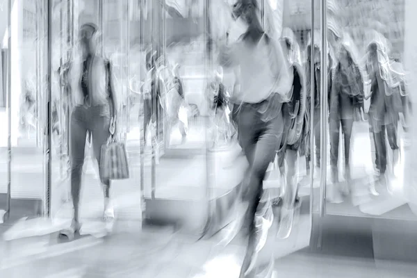 people shopping in the city in motion blur in monochrome blue tonality