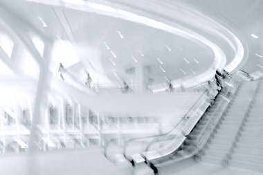 Bulanık bir geçmişi olan modern bir iş merkezinin lobisindeki insanların soyut görüntüleri.