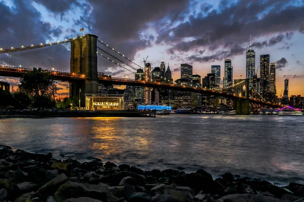 パノラマビューニューヨークのダウンタウンマンハッタンの高層ビルやブルックリン橋と夜のスカイライン — ストック写真