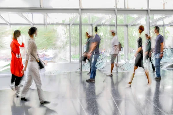 abstract image of people in the lobby of a modern business center with a blurred background