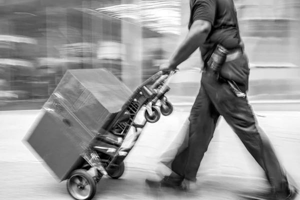 Delivery with dolly by hand in monochrome blue tonality — Stock Photo, Image