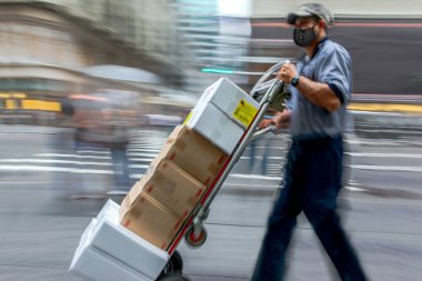 Şehirdeki maskeli iş adamları, oyuncak bebek ile mal teslimatı, kasıtlı olarak hareket bulanıklığı