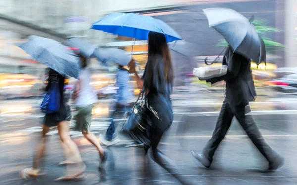 business people walking in the street  in medical masks on a rainy day motion blur