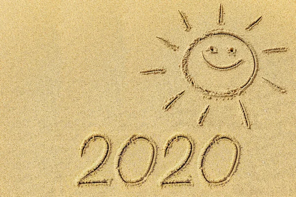 ビーチシーズンの象徴として海岸線の砂浜に太陽と2020を描く — ストック写真