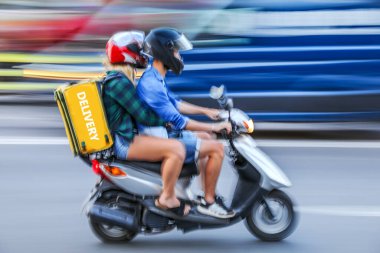 Şehir yolundaki maskeli iş adamları motosikletli ve motosikletli teslimat yapıyor.