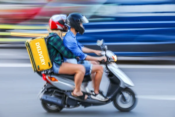 business people in masks in the city  roadway delivery on a motorcycle, motor scooter