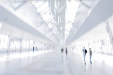 Bulanık bir geçmişi olan modern bir iş merkezinin lobisindeki insanların soyut görüntüleri.