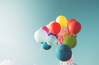 Bir retro vintage instagram filtre efekti ile mavi gökyüzü üzerinde renkli festival balonlar.