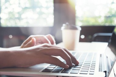 Yan görünümü ve yakın çekim Genç hippi kız el üstünde onu laptop bir kafede çalışıyor. bilgisayarlar bir kafede - film renk stili kullanan kadın.
