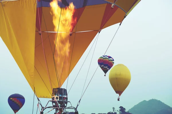 Close-up of hot air balloons with fire blue sky background applying retro and vintage filter effect styles.