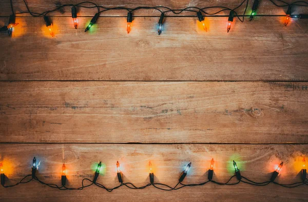 Vintage Christmas lights bulb decoration on old wood plank. Merry Christmas and New Year holiday background. vintage color tone.