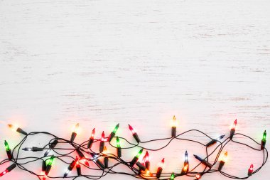 Noel ışıkları ampul dekorasyon ahşap beyaz üzerinde. Neşeli Noel ve Yılbaşı tatil arka plan. üstten görünüm