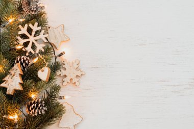 Noel arka plan - köknar bırakır ve rustik öğeleri beyaz dekorasyon ahşap tablo. Yaratıcı düz düzen ve kenarlık ve kopya alan tasarım ile üstten görünüm kompozisyon.