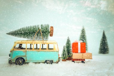 Vintage Merry Christmas Kartpostal arka plan - minyatür antika araba karlı kış orman içinde Noel ağaç çatı ve hediye (hediye kutusu) üzerinde taşıyan.