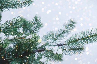 Işıklı Noel ağacına yakın çekim, kar taneciği. Noel ve Yeni Yıl tatili geçmişi. Klasik renk tonu.