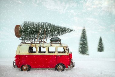Vintage Merry Christmas Kartpostal arka plan - minyatür antika araba karlı kış ormandaki çatıda Noel ağacı taşıyan.