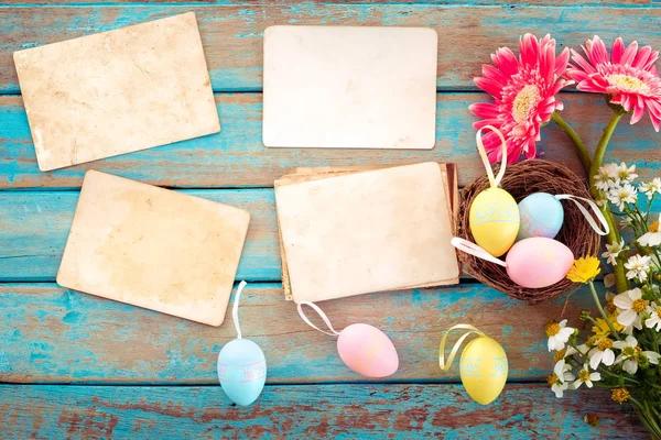 Renkli Paskalya yumurta yuvada çiçek ve ahşap masa - anma ve nostalji tatil kavramı bahar boş eski kağıt fotoğraf albümü ile. Vintage tarzı