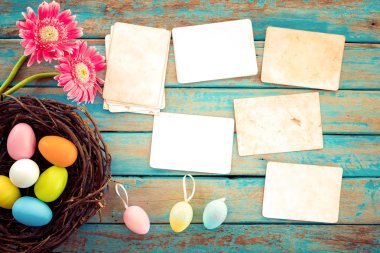 Renkli Paskalya yumurta yuvada çiçek ve ahşap masa - anma ve nostalji tatil kavramı bahar boş eski kağıt fotoğraf albümü ile. Vintage tarzı
