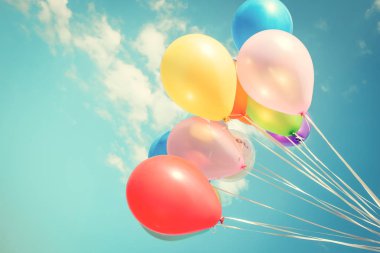 Bir retro vintage instagram filtre efekti ile mavi gökyüzü üzerinde renkli festival balonlar.