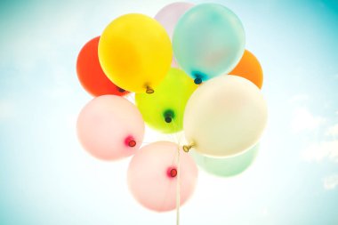 Vintage çok renkli balonlar ile mavi gökyüzü üzerinde bir retro instagram filtre etkisi ile yapılır. Yaz ve balayı konsepti düğün Sevgililer, aşk arka planı için fikirler.