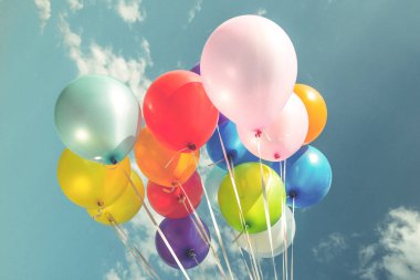 Bir retro vintage instagram filtre efekti ile mavi gökyüzü üzerinde renkli festival balonlar.