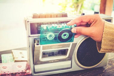Retro yaşam tarzı - teyp kaset kaset çalar ve kaydedici için dinlemek müzik ile tutan kadın el - vintage renk tonu efekti.