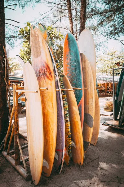 Bir yığın sahilde Kiralık kullanılabilir farklı renkli surf kurulları kümesi. Dikey sörf tahtaları, vintage renk tonu efekti.
