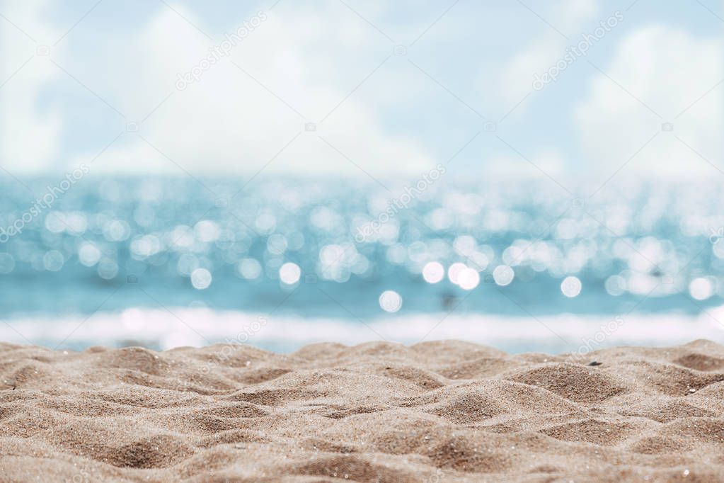 Seascape abstract beach background. blur bokeh light of calm sea and sky. Focus on sand foreground.