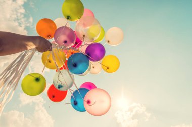 El bir retro vintage filtre etkisi ile yapılan çok renkli balonlar tutarak.