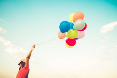 Çok renkli balonlar bir retro instagram filtre efekti, mutlu doğum gün yaz ve balayı düğün, Vintage renk tonu stili kavramı ile yapılan tutan kız el