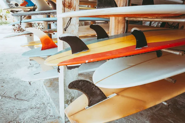 ビーチでレンタル可能スタック内の異なるカラフルなサーフボードのセットです ヴィンテージ色のトーン効果 — ストック写真