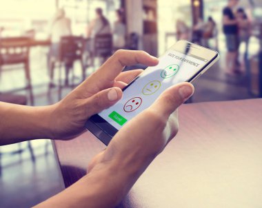 Akıllı telefon kullanan erkekler simge yüz gülümseme sembolü seçin. Müşteri hizmetleri deneyimi ve iş memnuniyeti anketi konsepti