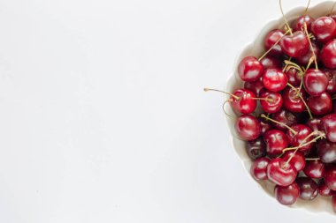 Hafif bir arka plan üzerinde bir porselen kase tatlı kiraz. Metin için kopya alanı olan resim. Taze çilek ve meyve, gıda, sağlık tasarım temaları için.