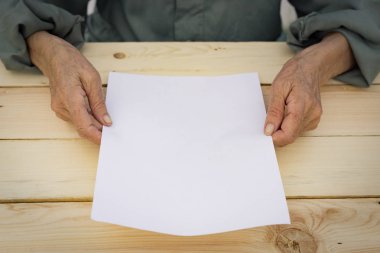 Eski eller boş bir kağıt tutuyor. Yeni başlangıçlar kavramı, aktif yaşlılık, vasiyetname.