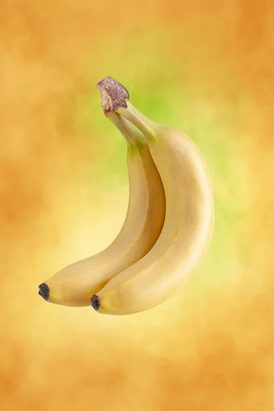 Two bananas on the yellow abstract background