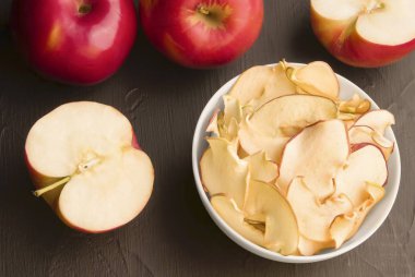 siyah bir arka plan üzerinde bir tabak meyve elma cipsi