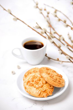 Bahar kahvaltısı. Hafif kahvaltı. Fıstıklı kurabiyeli kahve. Beyaz arka planda kahvaltı. Söğüt dalları