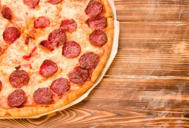 Tahta bir masada salamlı pizza. Akşam yemeği.