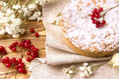 Beyaz çiçekler ve Rowan 'ın yanında tahta bir arka planda turta.