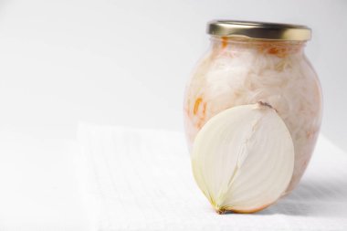 Fermented vegetables. Cabbage in a jar, next to half onion. Copy space