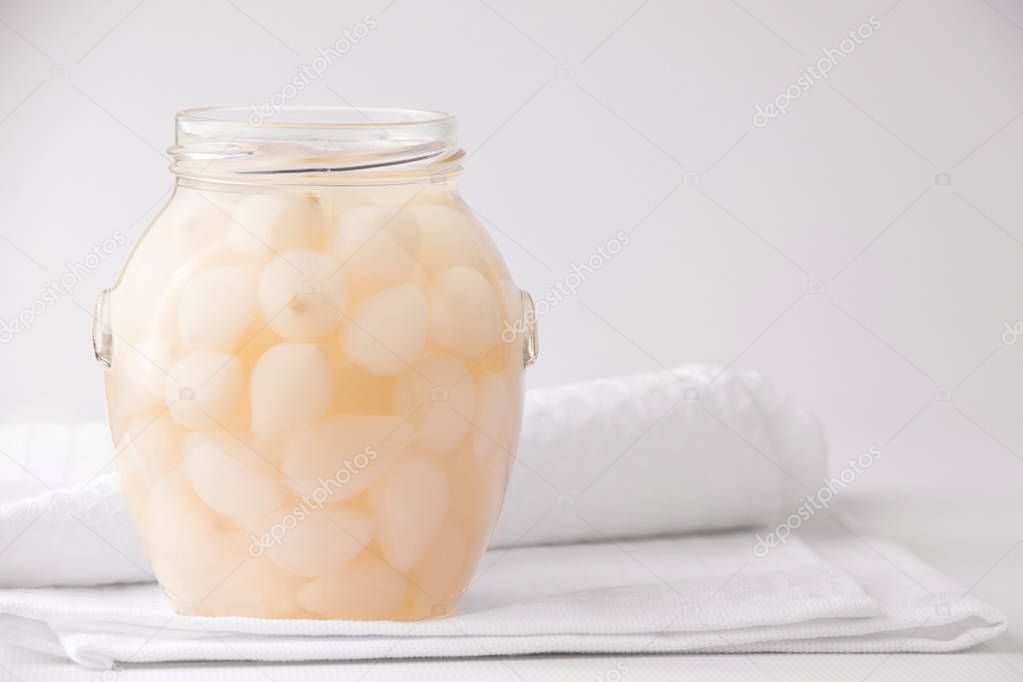 Fermentation Products. Fermented onions in a jar on a white background. Copy space