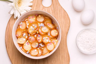 Çocukların kahvaltısı beyaz arka planda, malzemelerin yanında.