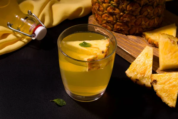 Siyah arka planda taze malzemelerin yanında ananas yaz içeceği. Boşluğu kopyala